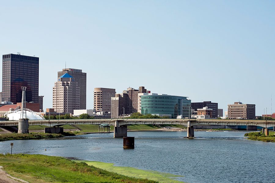 Ohio - City Skyline of Dayton Ohio and Riverside Bridge Against Blue Sky
